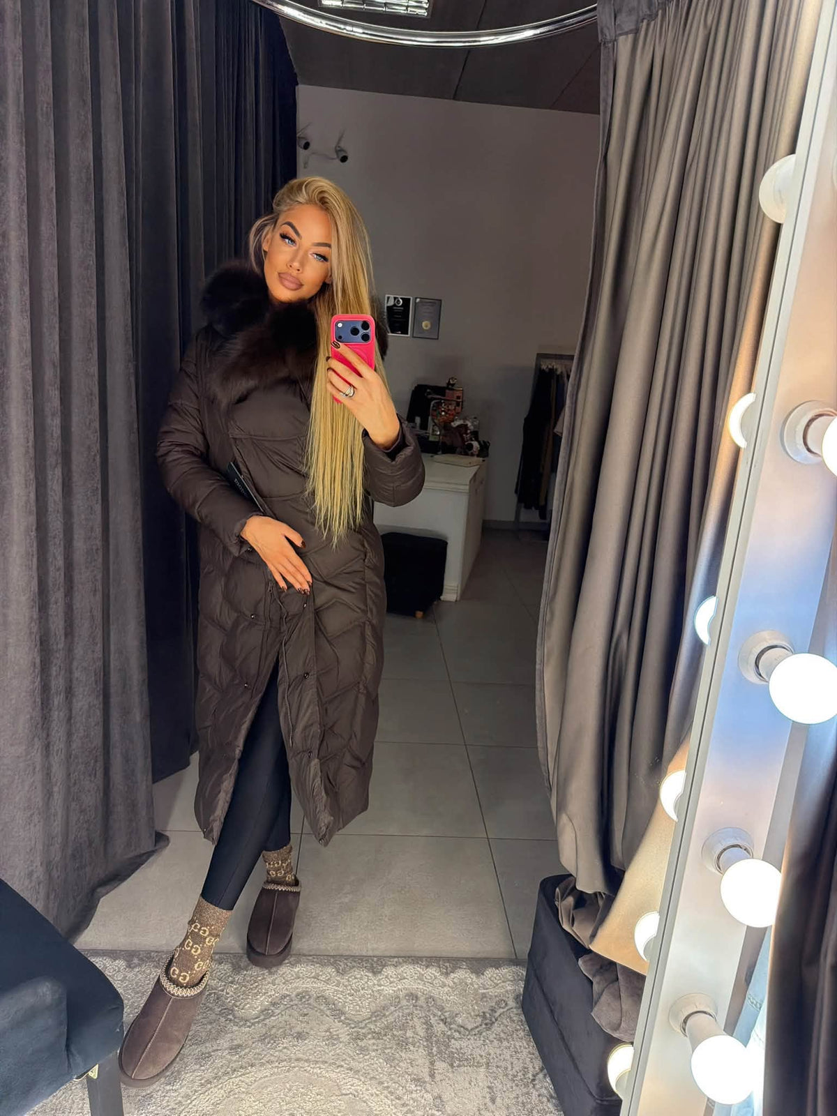 Brown long women's puffer coat with natural fur hood, worn open – front view